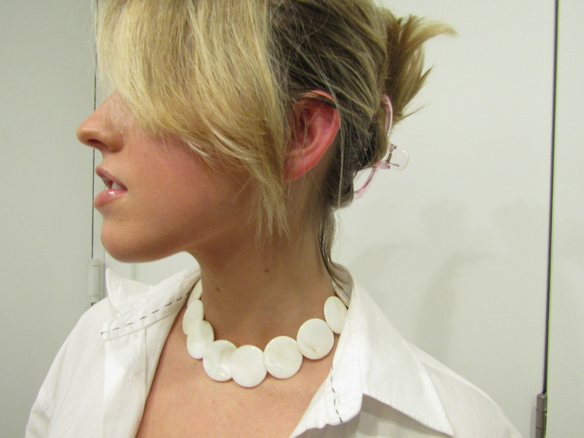 Model wearing the shell choker by rraine, featuring large shell beads and a gold-filled clasp, measuring 16.5 inches in length.